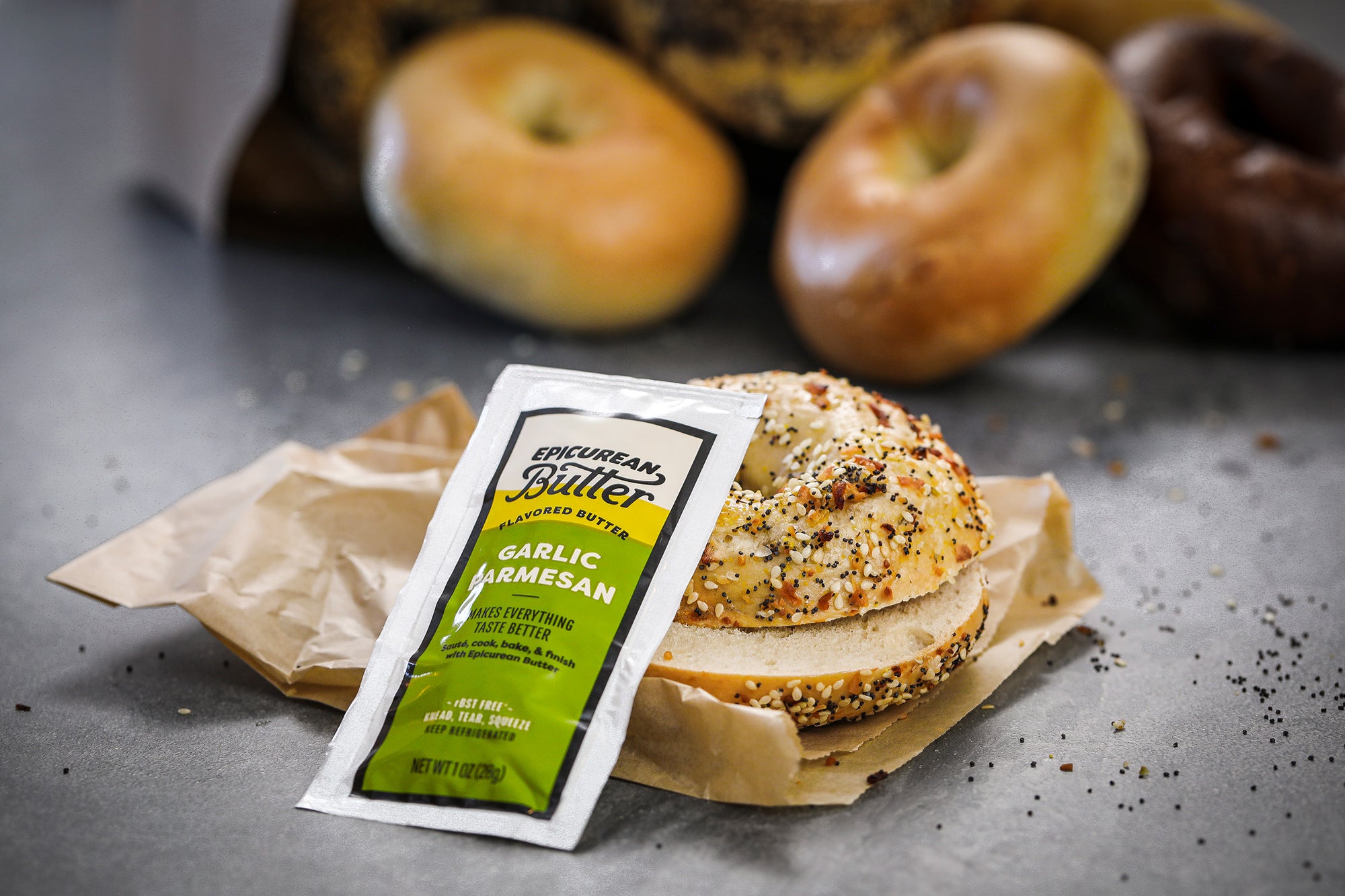 To-go bagel with packet of Epicurean Butter Garlic Parmesan Flavored Butter