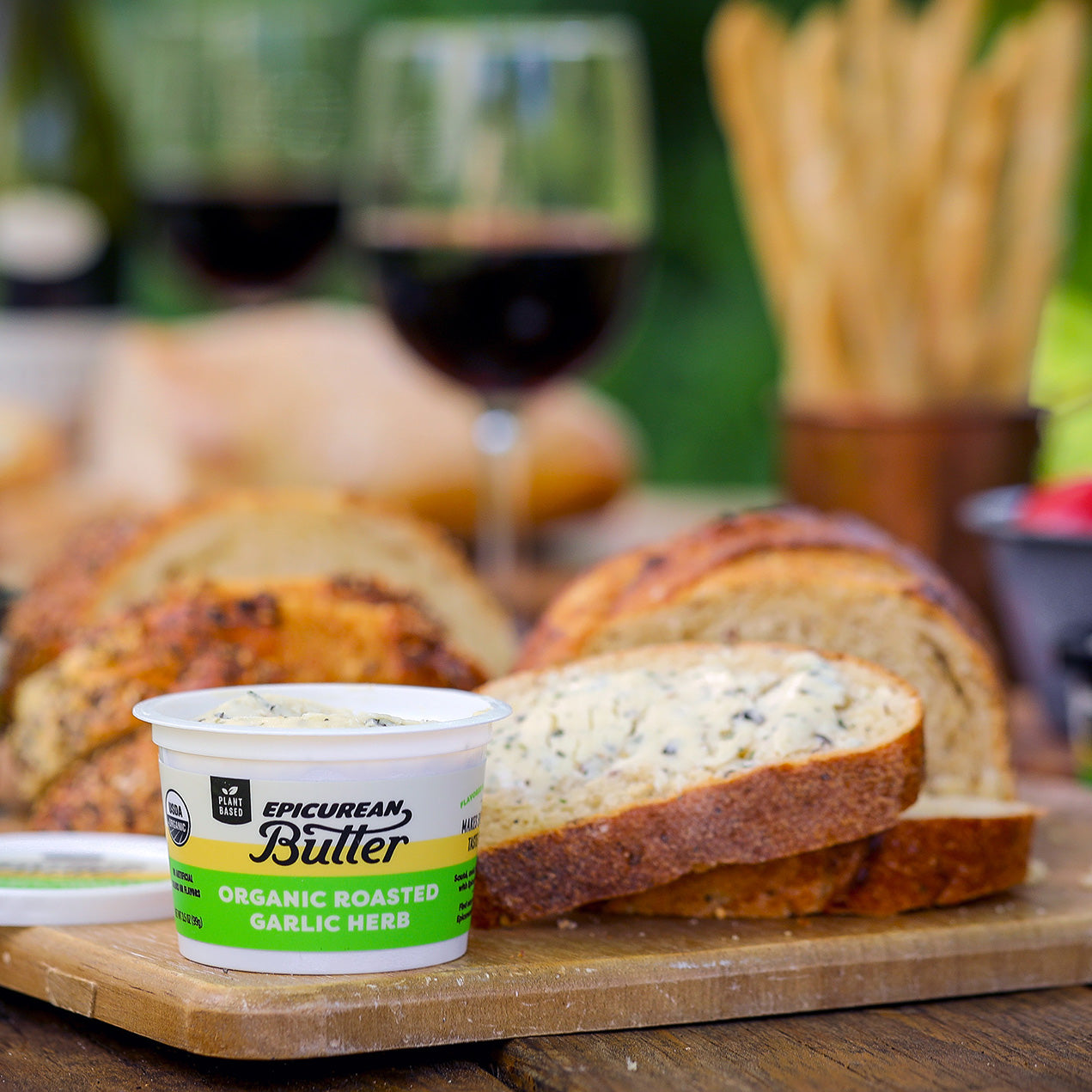 Organic Roasted Garlic Herb Flavored Plant Butter with bread and wine